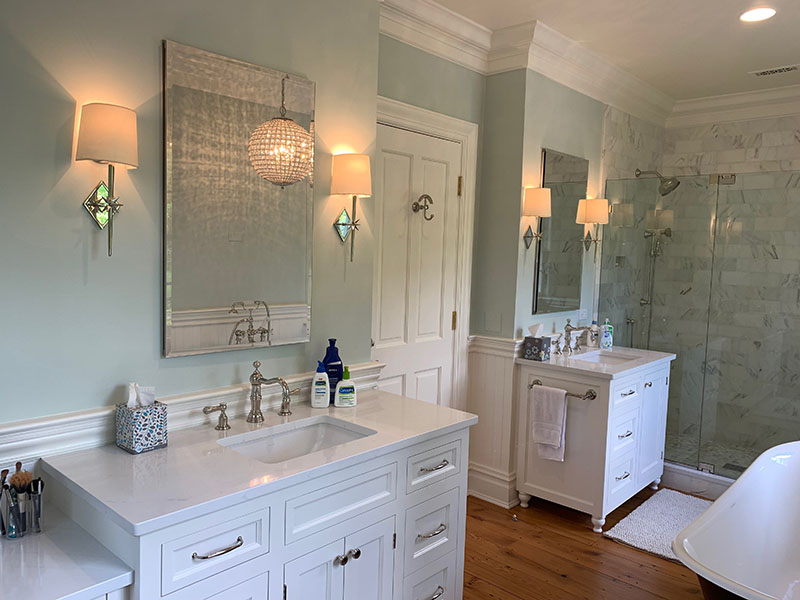 two Bathroom sinks with white cabinets, mirrors and countertop