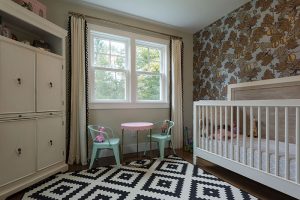 Room with a crib, closet, large windows, and childrens toys